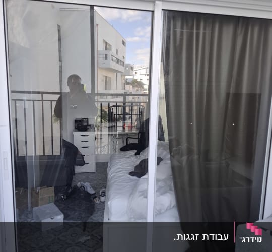 דלת הזזה מזכוכית עם מסגרת אלומיניום לבנה ביציאה למרפסת